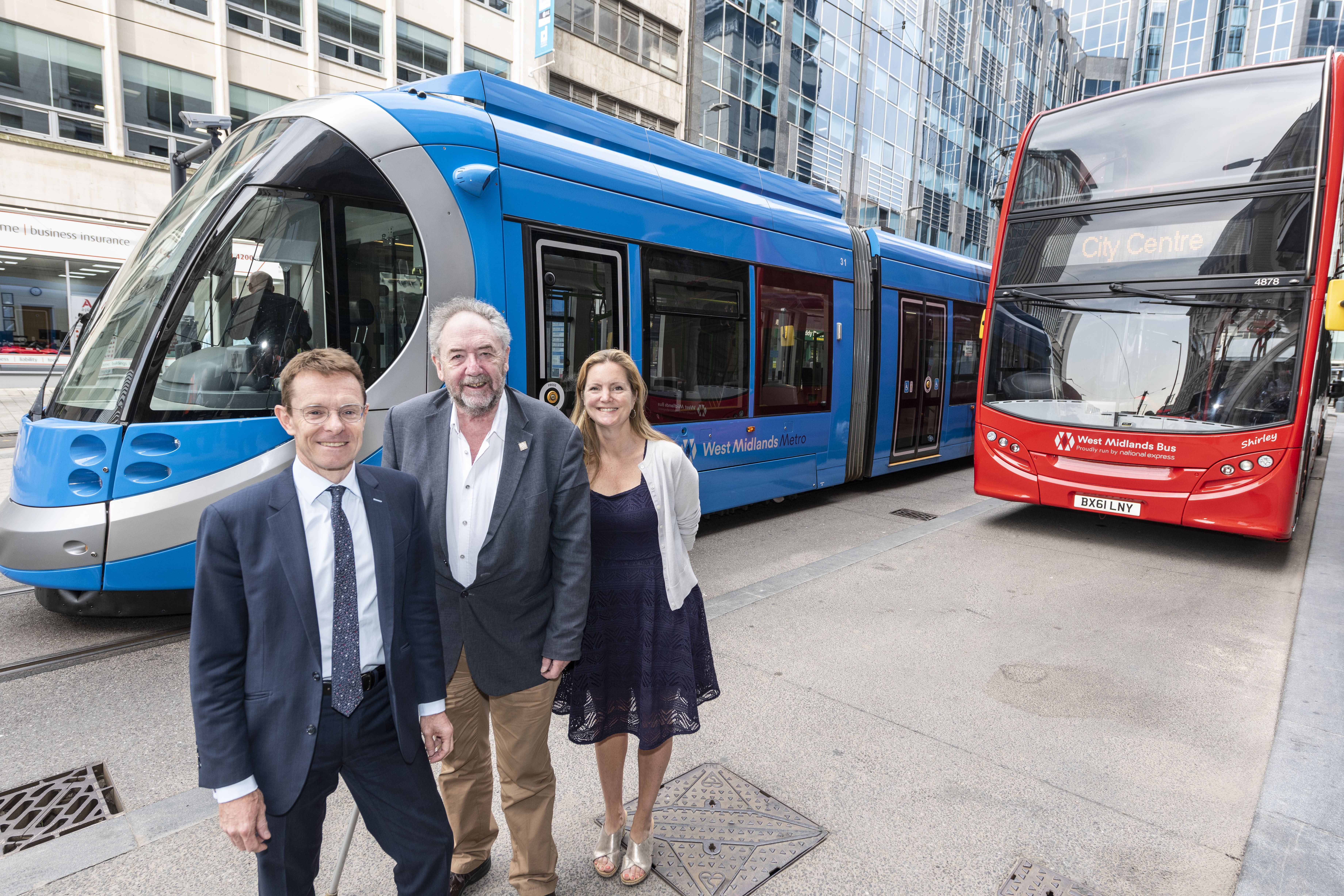 Andy Street, left, Cllr Roger Lawrence and Laura Shoaf with a tram and bus in their new West Midlands Transport livery.