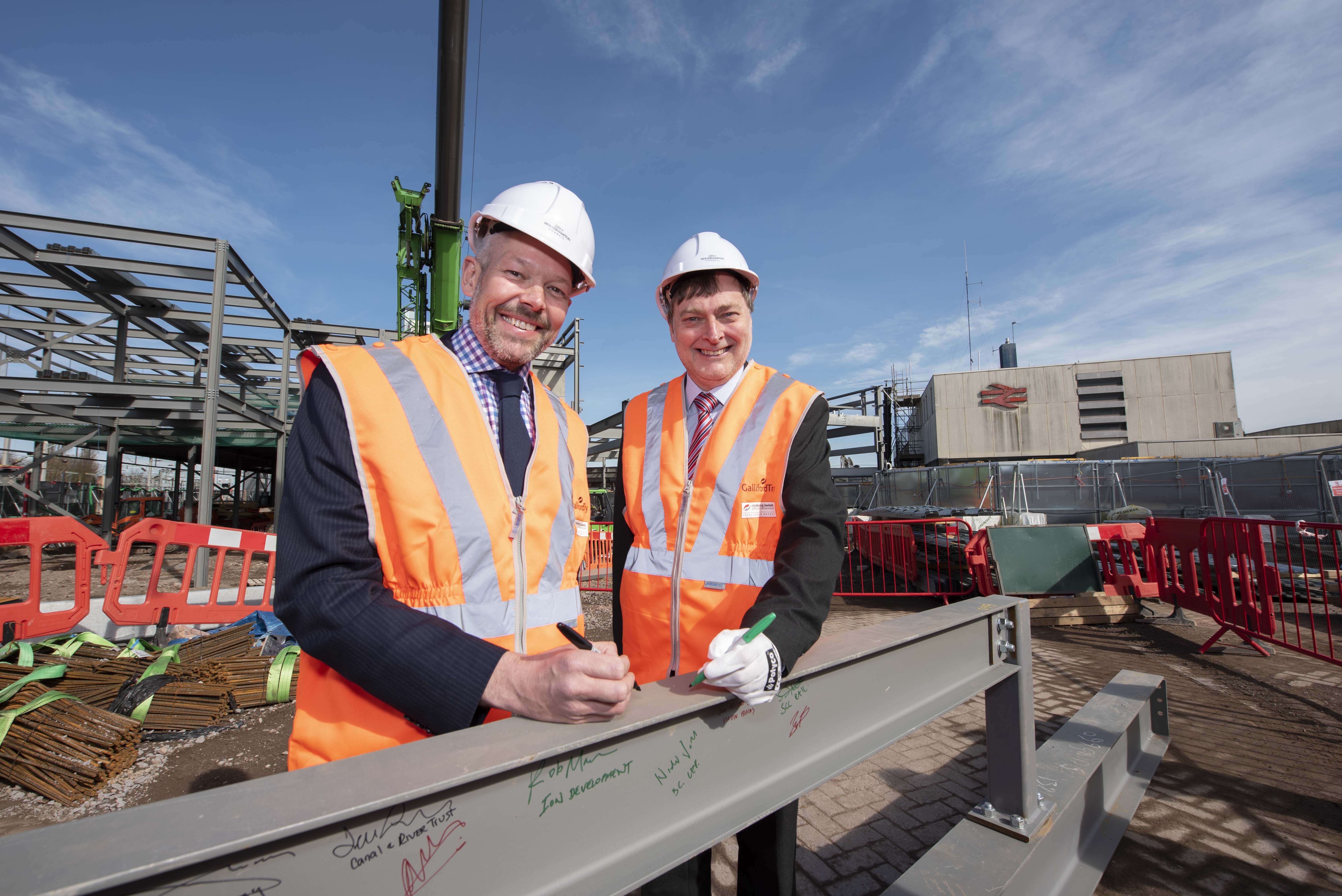 Malcolm Holmes (left), director of rail at Transport for West Midlands and Cllr John Reynolds, City of Wolverhampton's cabinet member for city economy, sign the steel rails that will form the structure of the new rail station