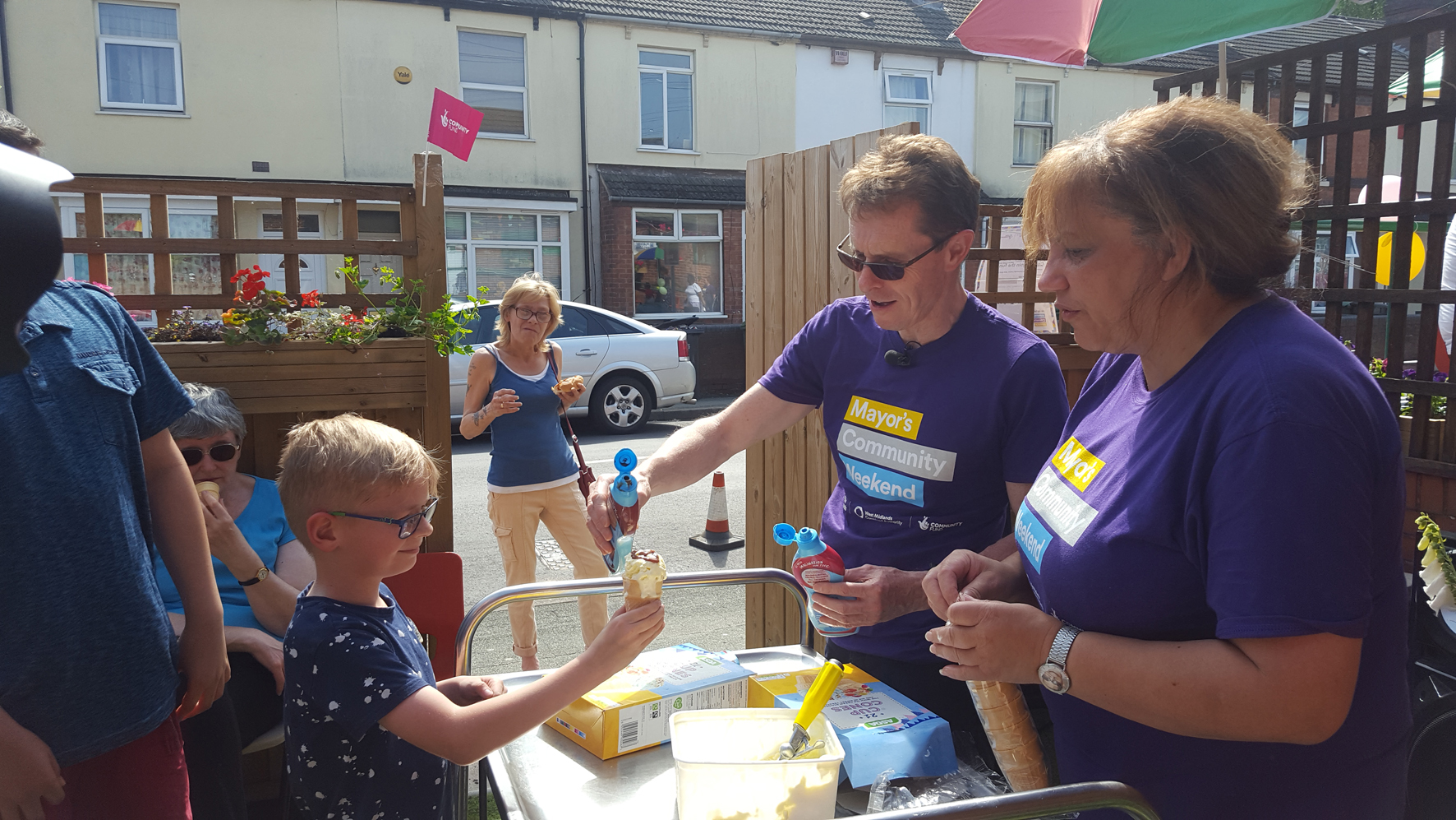 Mayor of the West Midlands Andy Street serves a youngster ice-cream with chocolate sauce at the Community Barbecue Build and Plant event at the Stratton Street Community Centre, Wolverhampton