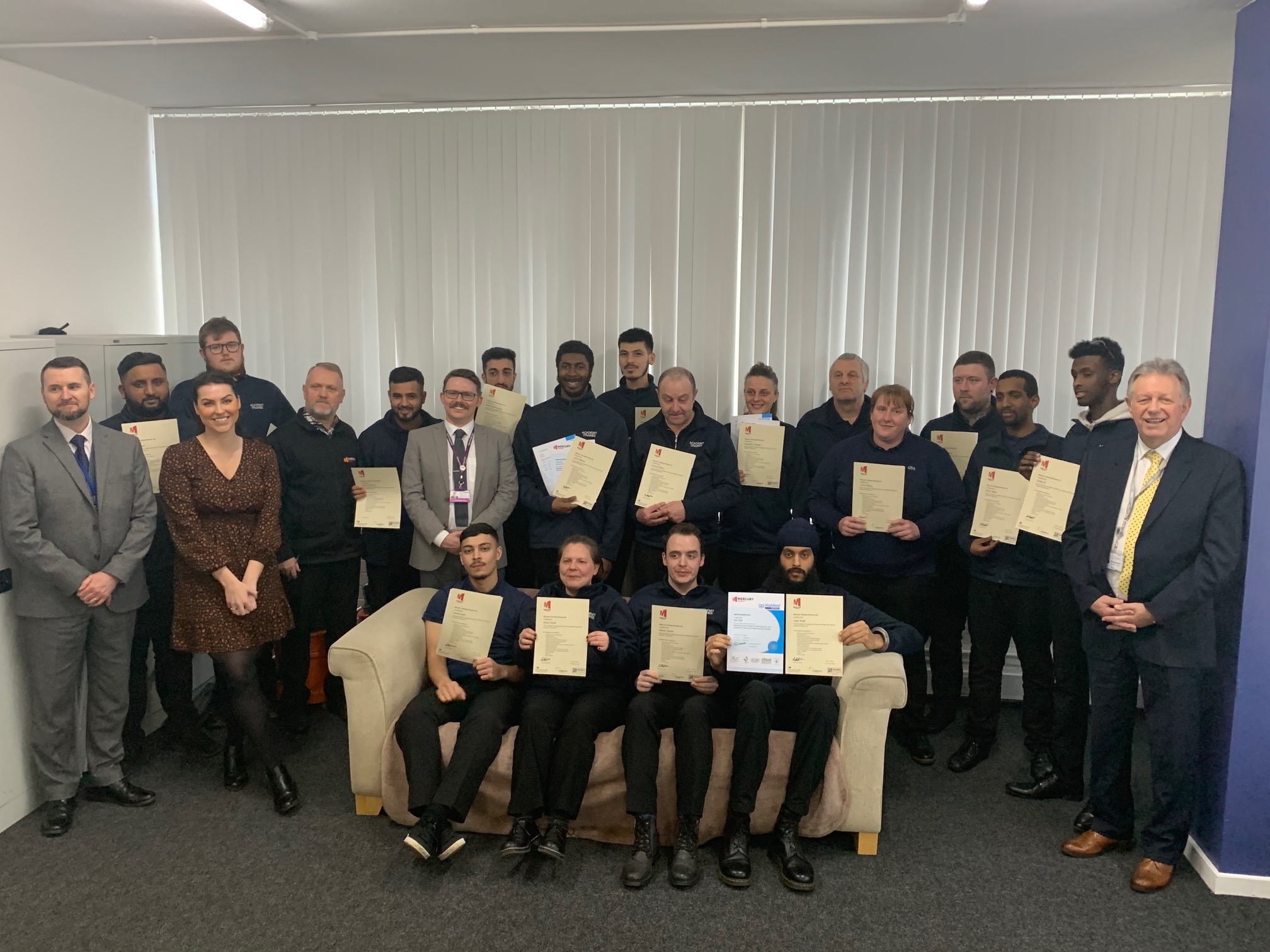 Nineteen learners celebrate getting new jobs in the security sector with (left) Paul Lawton-Jones from Mercury Training, (third left) Maria Randall from Man Commercial Protection, (seventh left) Graham Reynolds from Telford College and (right) Philip Tillman from the WMCA