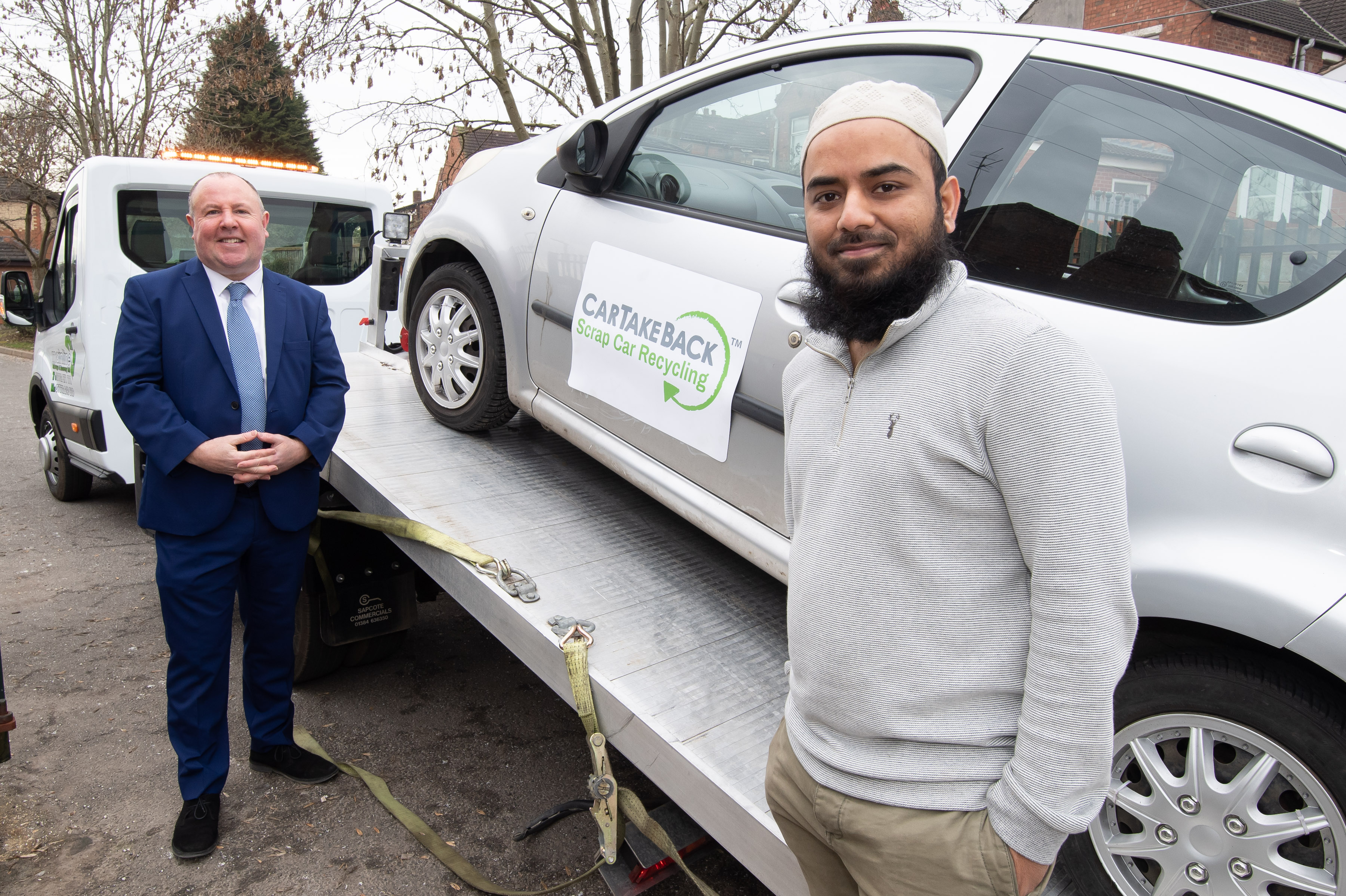 Mohammed Fasiuddin with cllr Jim O'Boyle as the car is taken away for recycling