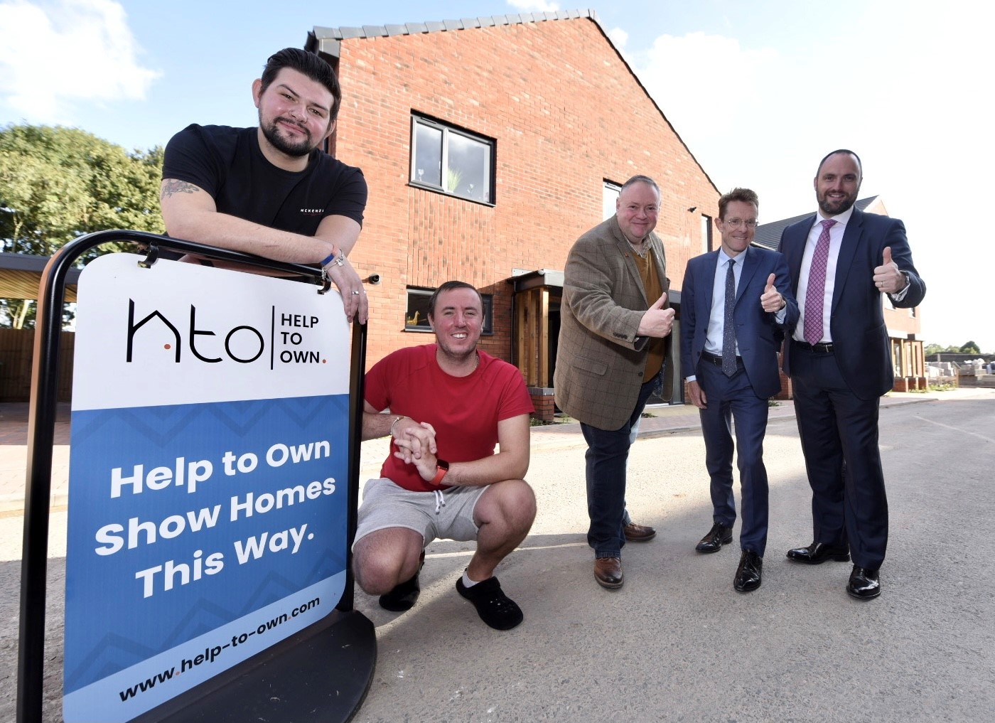 Help to Own tenants Timothy Perry (front left) and  Aaron Parsons (front right) outside their new home with (rear left to right) Cllr Stephen Simkins, Deputy Leader of City of Wolverhampton Council, Andy Street, Mayor of the West Midlands and chair of the WMCA and Sam Miller, Commercial Director - New Propositions at FDC