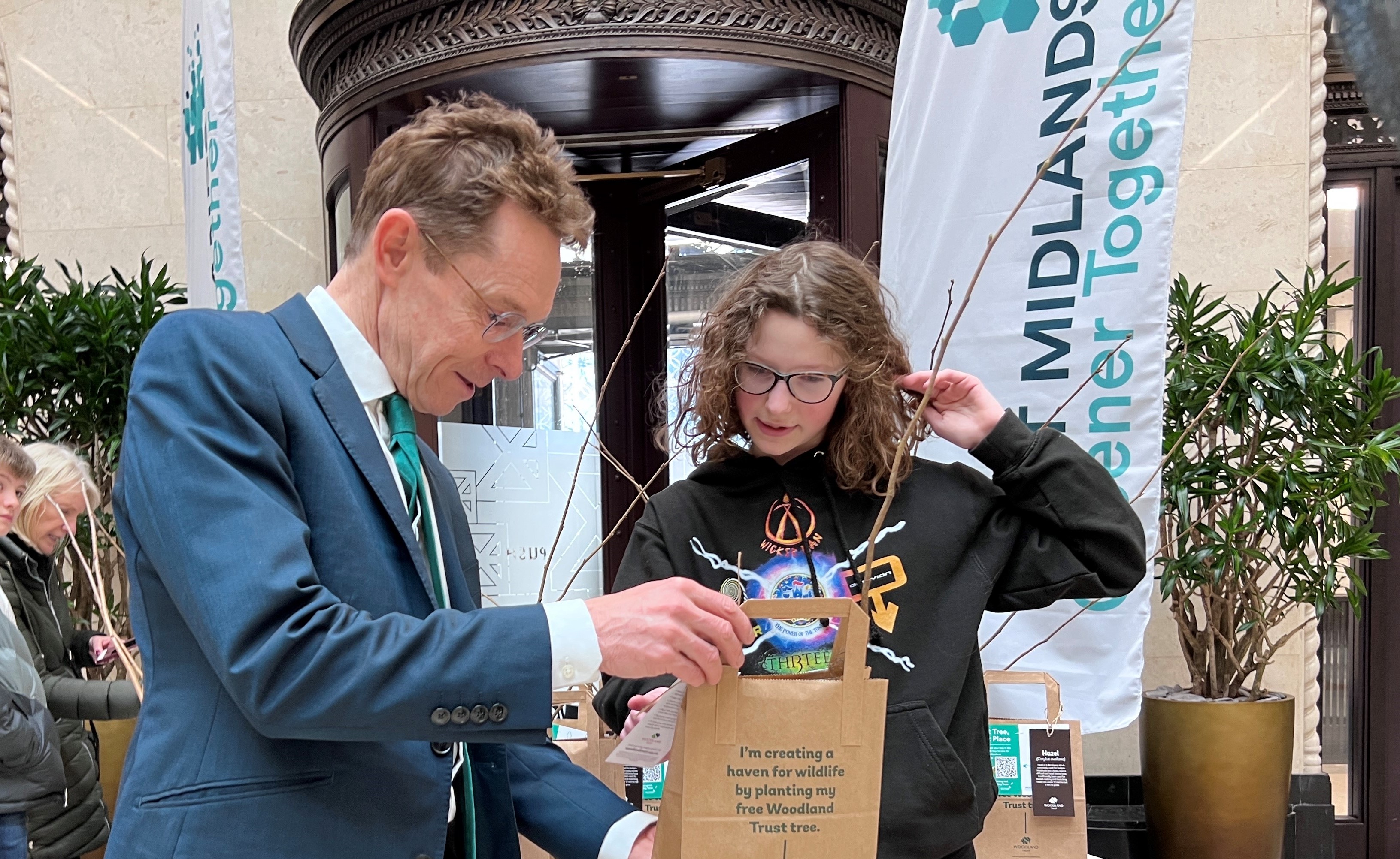 Mayor Andy Street hands a tree to 13-year-old Betty Green at the Exchange