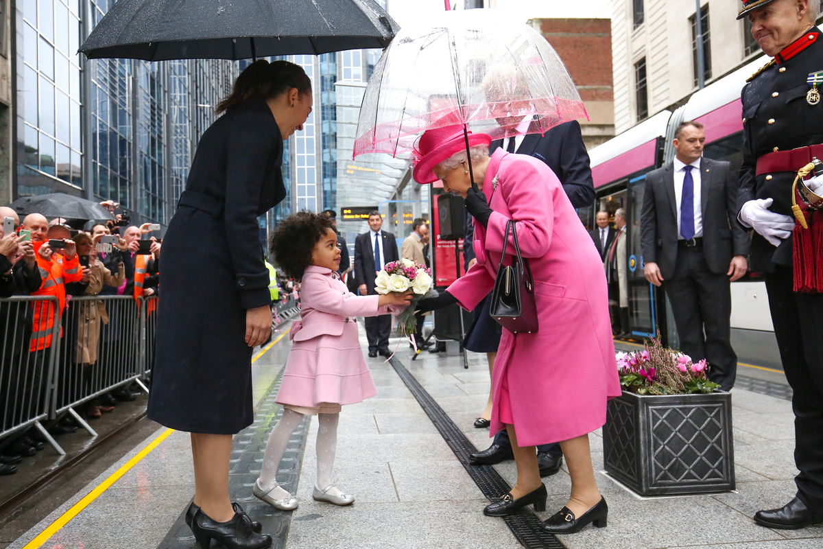 Sophie Allison and daughter Taahlia present the Queen with a bouquet of flowers during her visit to Birmingham to name one of the West Midland Metro trams in 2015